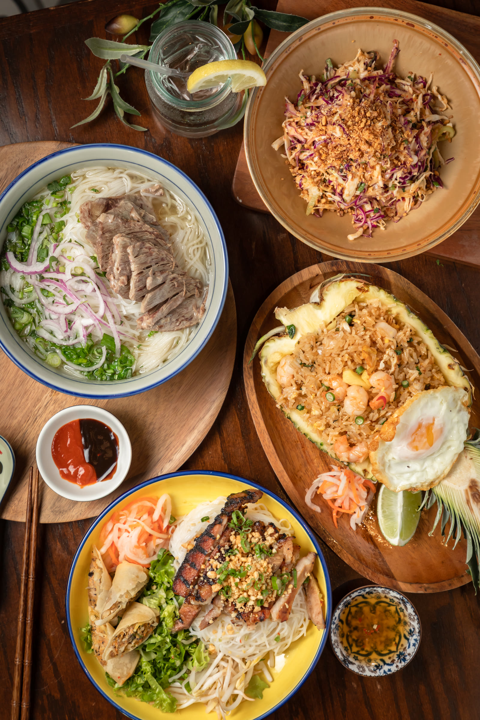 Overhead Vietnamese spread: pho, pineapple fried rice and vermicelli bowl