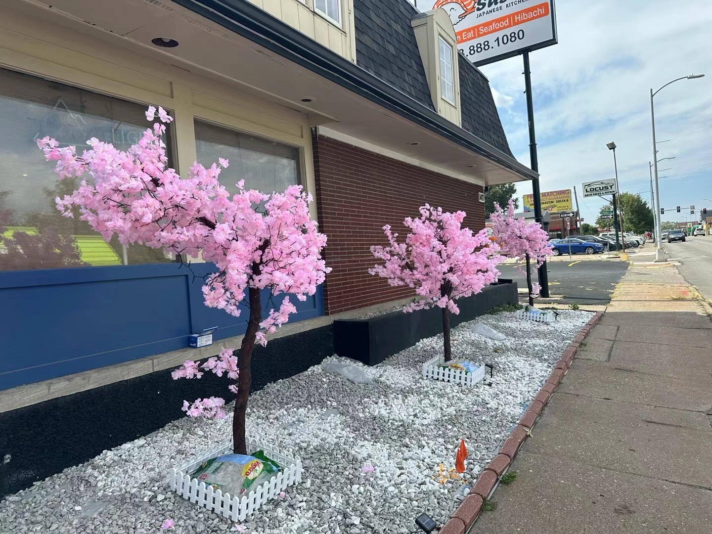Restaurant storefront with cherry-blossom trees and signage